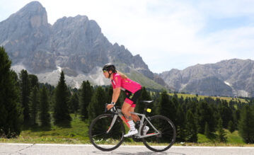 Carola Skarabela fährt auf ihrem Rennrad durch eine traumhafte Bergkulisse