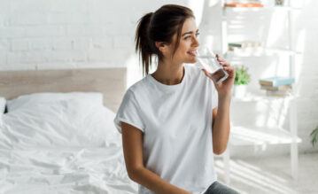 Frau trinkt beim Fasten morgens ein Glas Wasser
