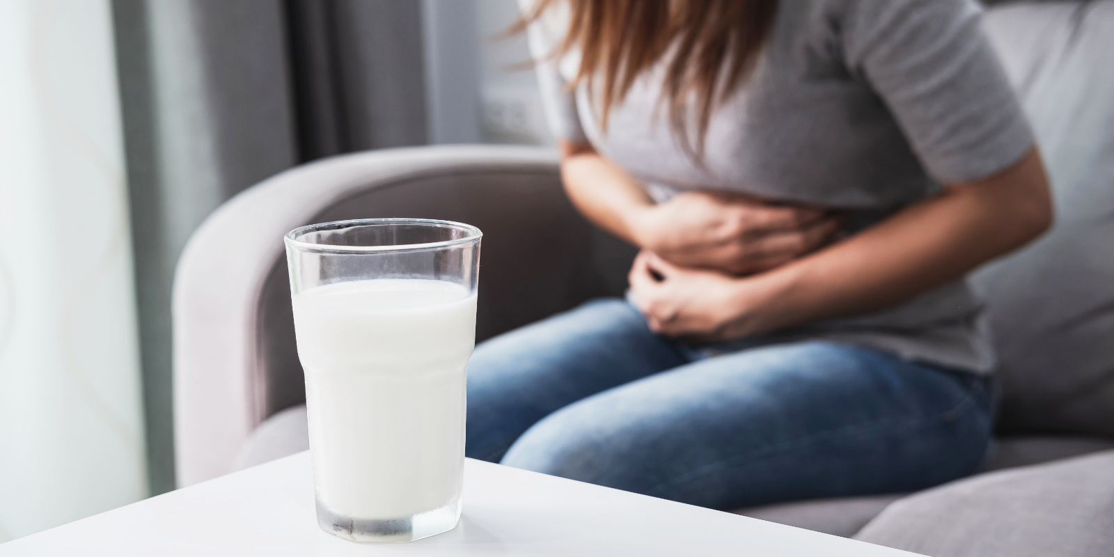 Fau mit Laktoseintoleranz hat Bauchschmerzen nach einem Glas Milch