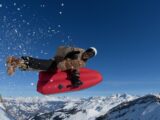 Mann fliegt beim Airboarding in den Bergen durch die Luft