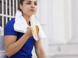Sportlerin isst nach einer kleinen Runde eine Banane
