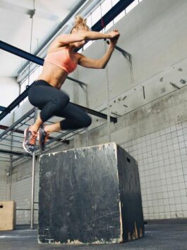 Sportlerin springt auf Kasten