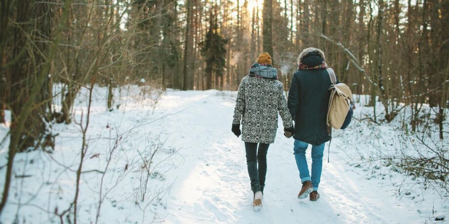 Zwei Personen machen einen Winterspaziergang im Wald