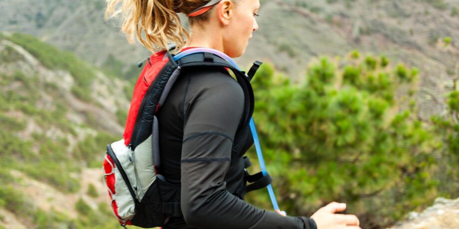 Frau trägt beim Trailrunning einen Rucksack