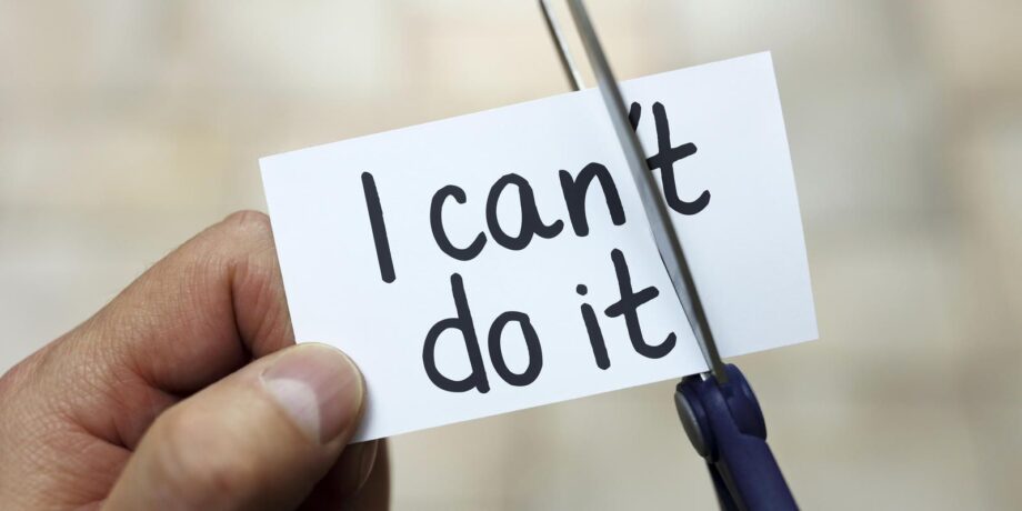 Mann zerschneidet Zettel und macht so aus einem „I can´t do it" ein „I can do it"