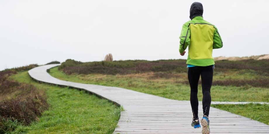 Läuferin absolviert ihr Lauftraining trotz Regen mit der richtigen Laufbekleidung