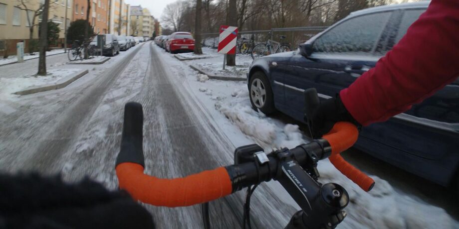 Radfahrer auf einer verschneiten Straße in der Stadt