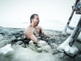 Mann nimmt ein Eisbad im zugefrorenem Meer