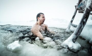 Mann nimmt ein Eisbad im zugefrorenem Meer