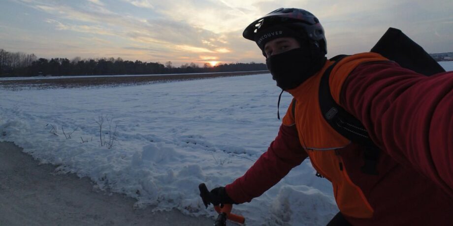 Felix fotografiert sich selbst beim Radfahren auf einem verschneiten Landweg