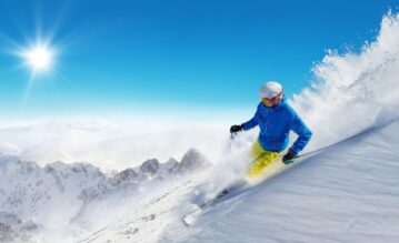 Skifahrer fährt einen Berg in den Alpen hinunter
