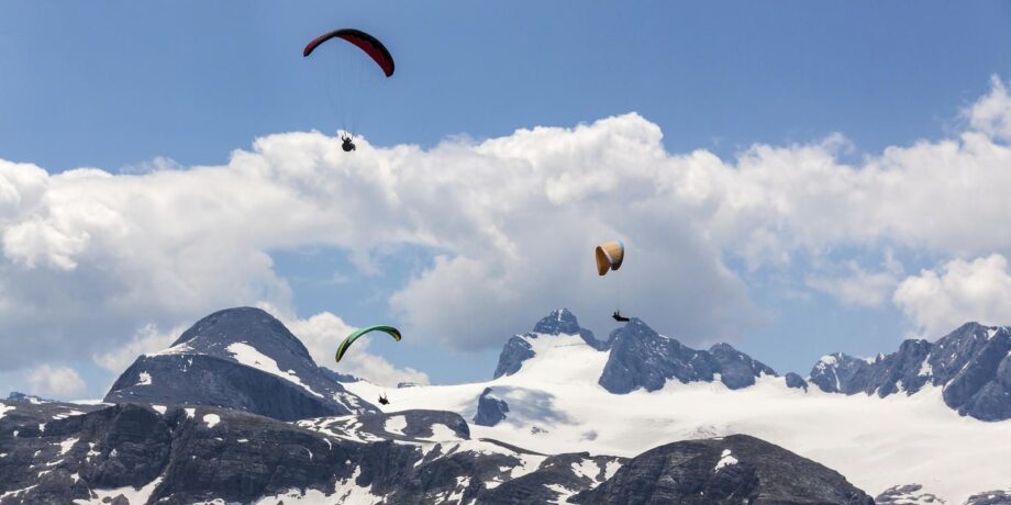 Mehrere Sportler fliegen beim Speedflyiing mit ihren Skiiern durch die Luft.