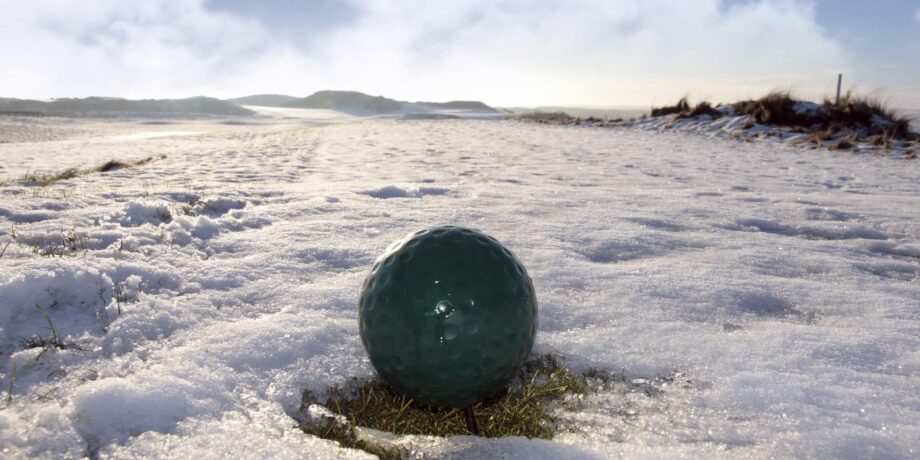 Golfball liegt beim Schneegolfen in der Winterlandschaft.