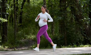 Schwanger Frau joggt durch einen Park