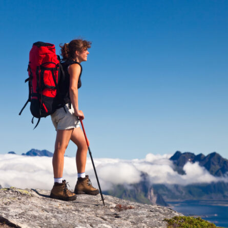 Frau mit Wanderausrüstung auf einem Berg