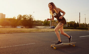 Junge Frau beim Longboardfahren auf der Straße
