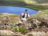 Mann und Frau laufen beim Trailrunning durch bergiges Gelände