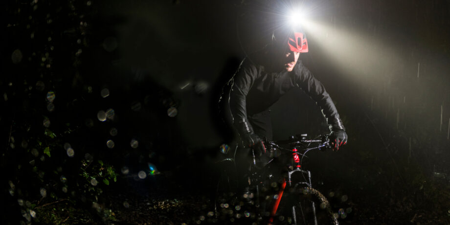 Mountainbiker fährt nachts mit der Varia Helmlampe durch das Gelände