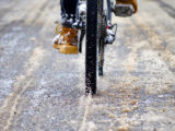 Fahrradfahrer fährt mit seinem Fahrrad im matschigen Schnee