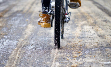 Fahrradfahrer fährt mit seinem Fahrrad im matschigen Schnee