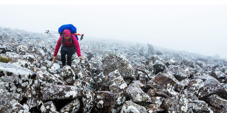 Kathrin Heckmann klettert beim Trekking über ein Feld voller Steine und Felsbrocken