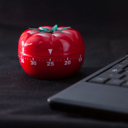 Uhr in Form einer Tomate neben einem Laptop