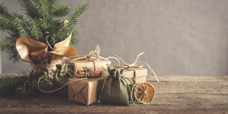 nachhaltig verpackte Geschenke, dekoriert mit Tannenzweigen und getrockneten Orangenscheiben