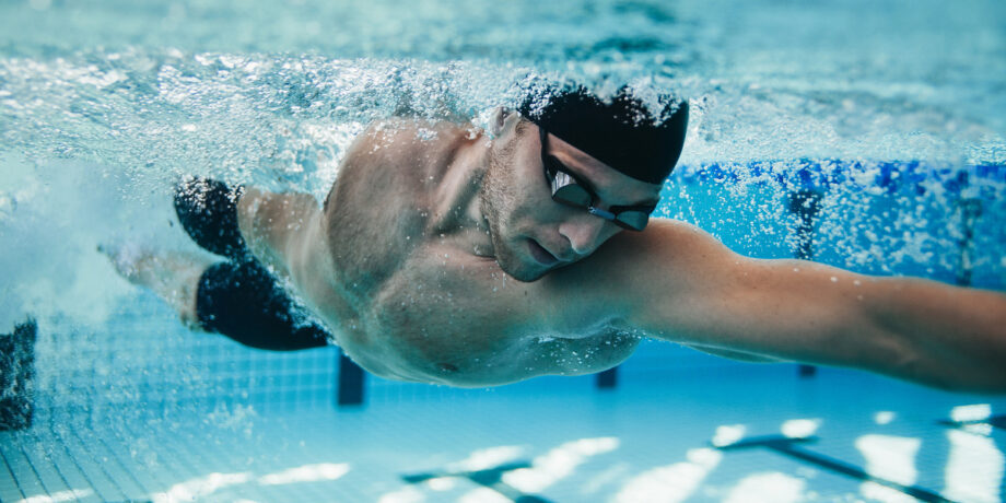 Schwimmer krault im Wasser eines Schwimmbeckens