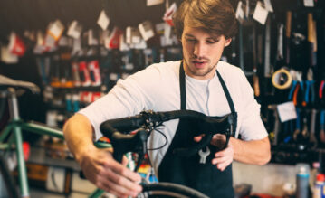Verkäufer im Fachgeschäft für Fahrräder stellt den Lenker richtig ein