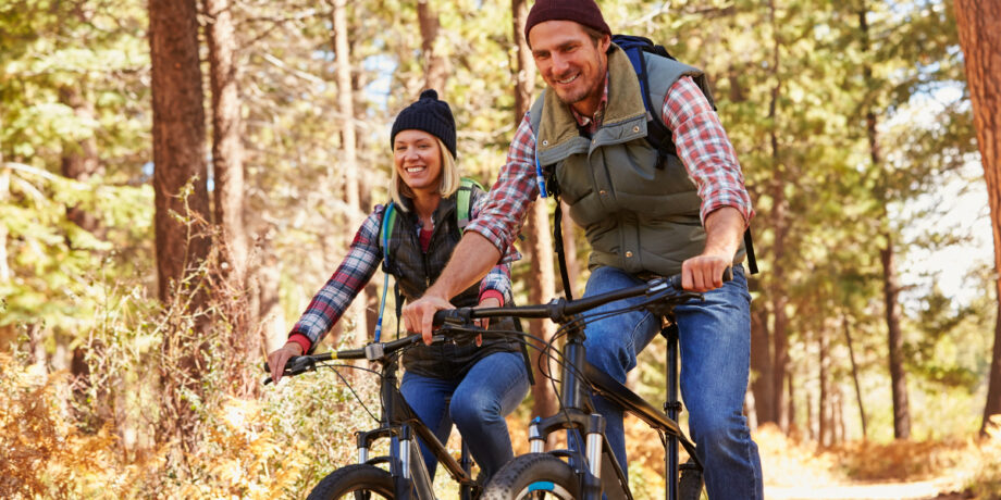 Mann und Frau beim Mountainbiking im Wald