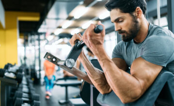 Sportler mit extremen Bizeps trainiert im Fitnessstudio