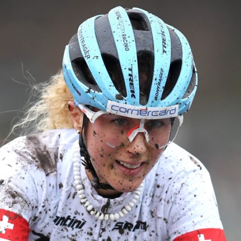 Mountainbikerin Jolanda Neff lächelnd beim Rennen - mit Schlamm im Gesicht. ©Ryan Bodge