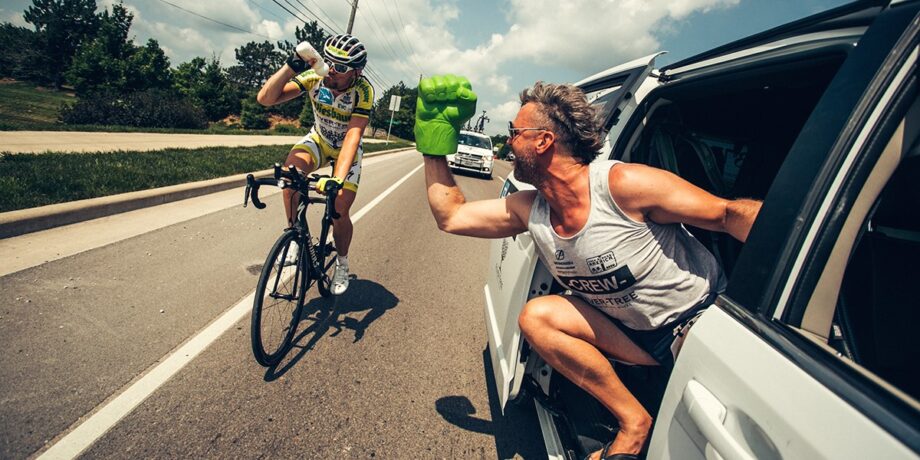 Christoph Strasser wird beim Ultra Radrennen RAAM auf dem Fahrrad von seinen Begleitern angefeuert