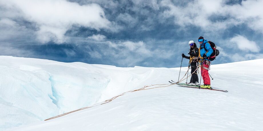 Das Paar auf Skiern am Sicherungsseil im Schnee.