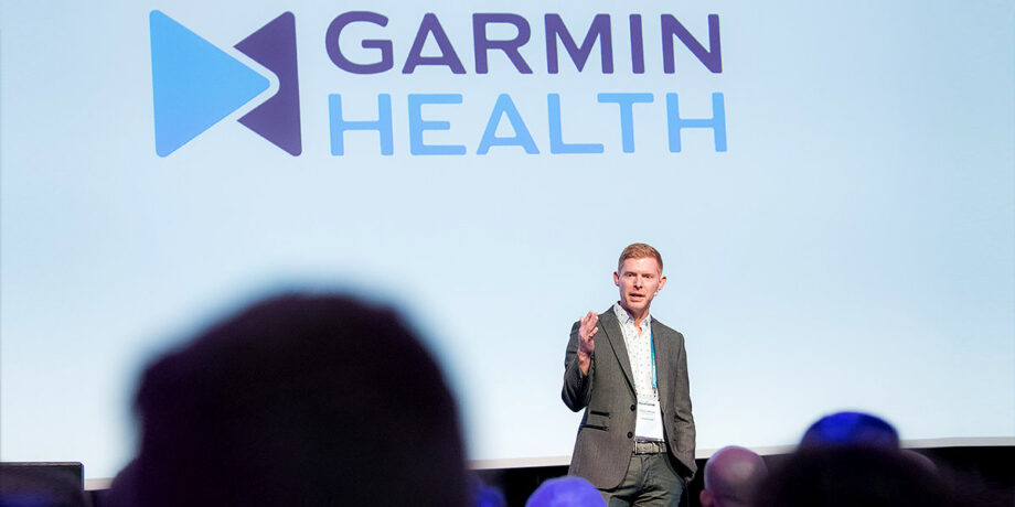 Travis Johnson hält auf der Bühne auf dem Garmin Health Summit in Amsterdam einen Vortrag