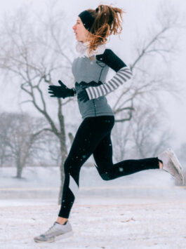 Frau joggt im Winter im Schnee