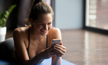 Frau nutzt eine Fitness-App für ihr Home-Workout