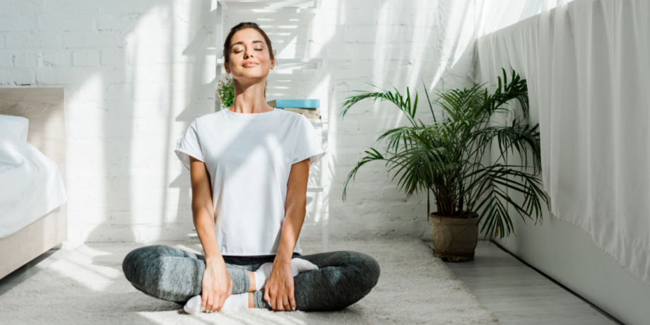 Junge Frau macht zuhause Yoga, um sich körperlich und mental fit zu halten