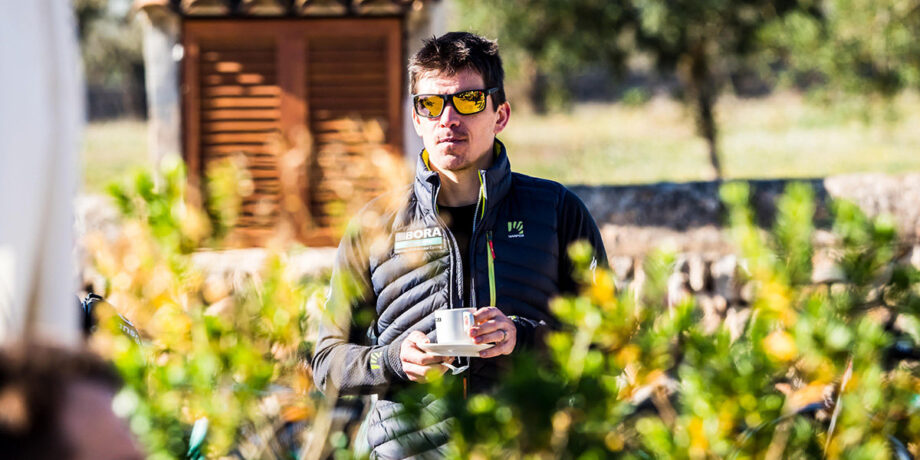 Dan Lorang steht mit einem Kaffee in der Hand in seinem Garten