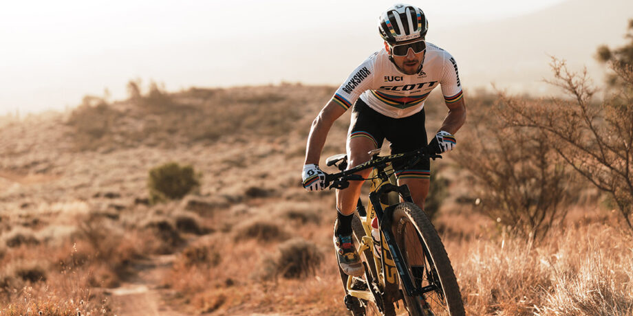 Nino Schurter fährt auf seinem Mountainbike durch eine Wüstenlandschaft