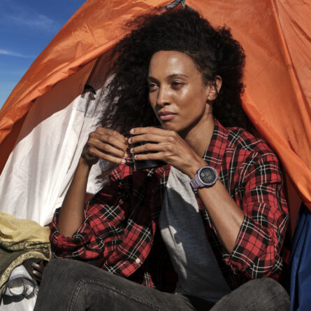 Frau trinkt ihren Kaffee im Zelt auf einem Berg