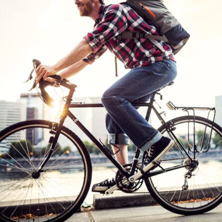 Mann fährt mit dem Fahrrad durch die Stadt zur Arbeit
