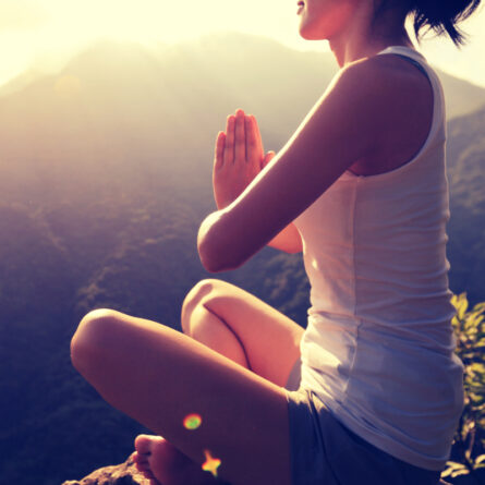 Junge Frau macht Yoga bei Sonnenaufgang