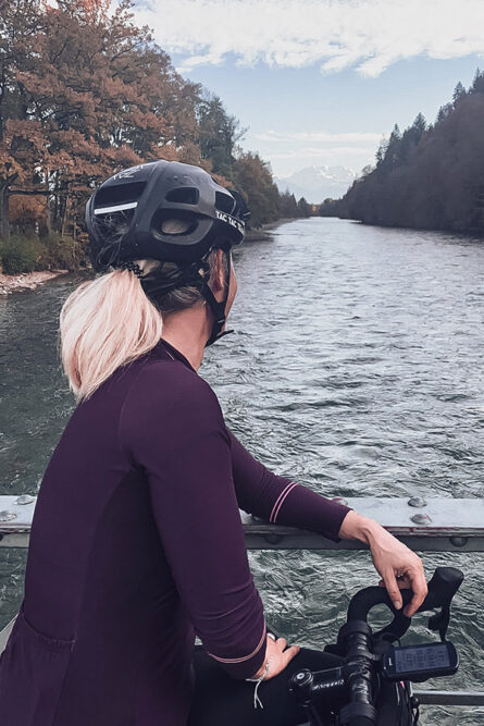 Ana Kummer sitzt auf ihrem Rad auf einer Brücke und schaut auf den Fluss