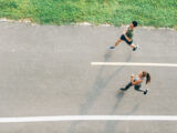Frau und Mann joggen draußen mit Abstand