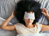 Frau beim Schlafen auf dem Rücken mit Schlafmaske
