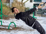 Fitnesstrainer Gino Singh hängt an Turnringen im Garten