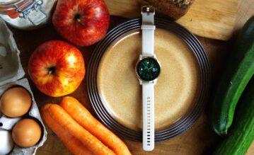Gesunde Lebensmittel liegen neben einer Garmin Uhr auf dem Tisch