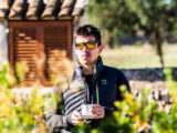 Dan Lorang steht in einem Garten mit einer Tasse in der Hand
