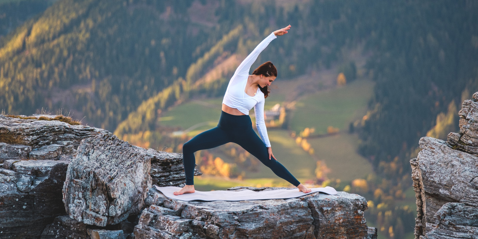 Klara Fuchs macht Yoga-Übungen auf einem Berg in traumhafter Kulisse